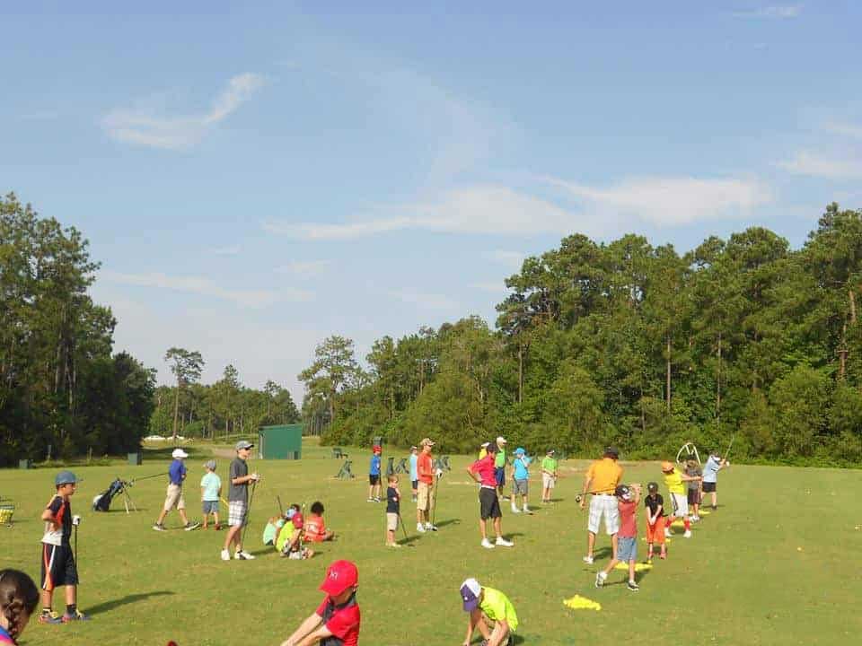 a group of people standing on top of a lush green field