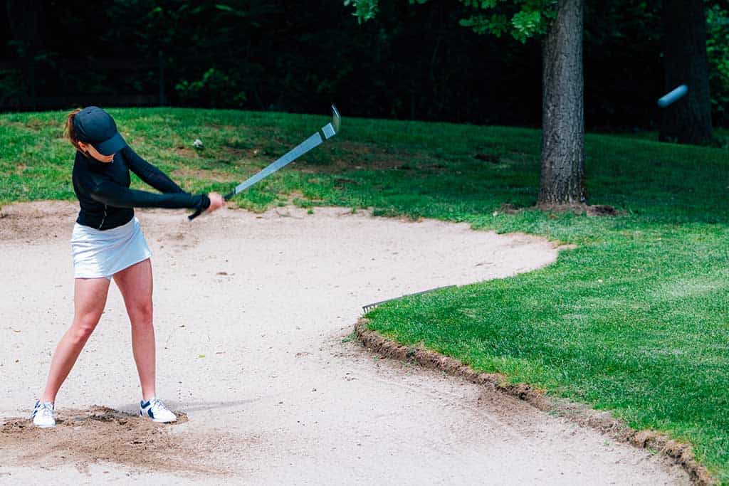 Golf Basics 4 a woman hitting a ball with a bat