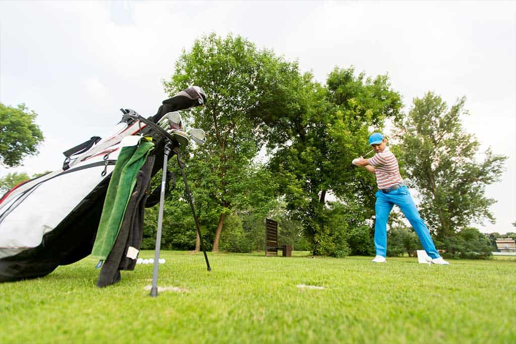 6 tips for playing golf in the wind 5 a man standing on top of a lush green field
