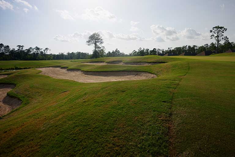 Best golf course for beginners in Louisiana 2 a golf course with sand bunkers and trees in the background