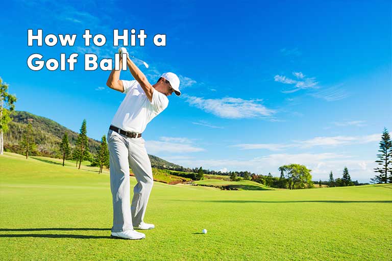 Man in white attire swinging a golf club on a sunny, grassy golf course with trees and hills in the background. text overlay: "how to hit a golf ball.