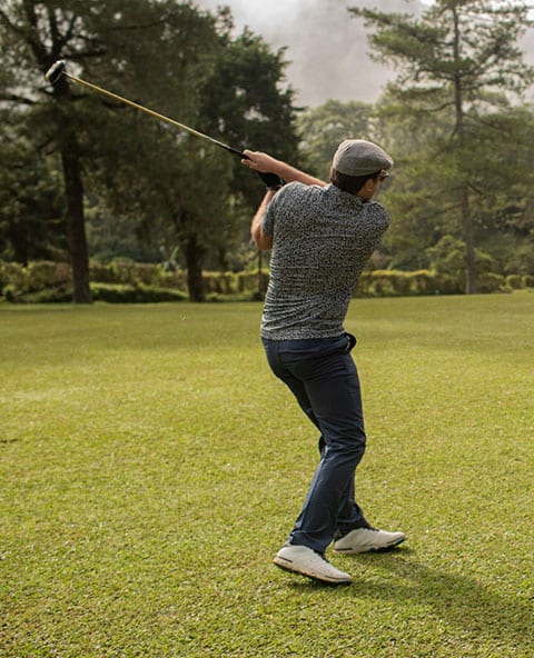 The Ultimate Guide: Perfecting the Basics of the Golf Swing 3 a man swinging a golf club on top of a lush green field