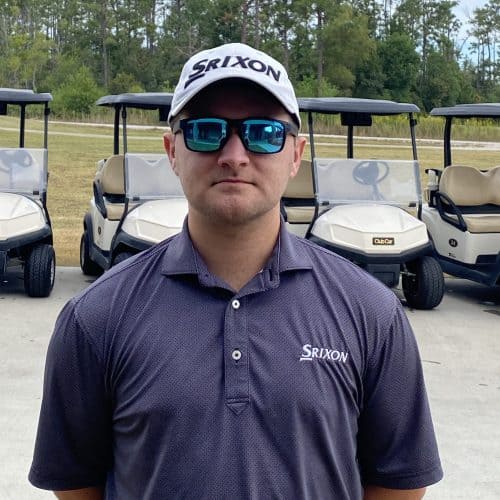 a man standing in front of several golf carts